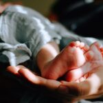 foto de dois pezinhos de bebê e um mão por baixo, Capa do post mensagens para bebê que vai nascer
