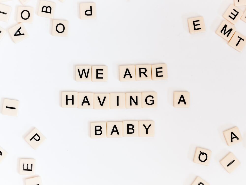 quadrados com letra formando uma frase: we are having a baby, para ilustrar o tema mensagens para bebê que vai nascer