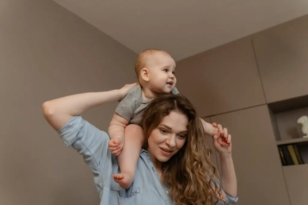 imagem de um mãe segurando o filho nos ombros, para ilustrar o dia a dia corrido e sobrecarregado de uma mãe e o que a Alexa pode fazer para ajudar com o bebê. Alexa para bebês