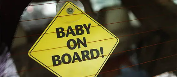 logomarca baby on board em losango amarelo, grudado no vidro do carro, berço postatil safety 1st